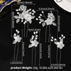 A set of white pearl flower bridal hair clips with varying lengths and sizes displayed against a black background.
