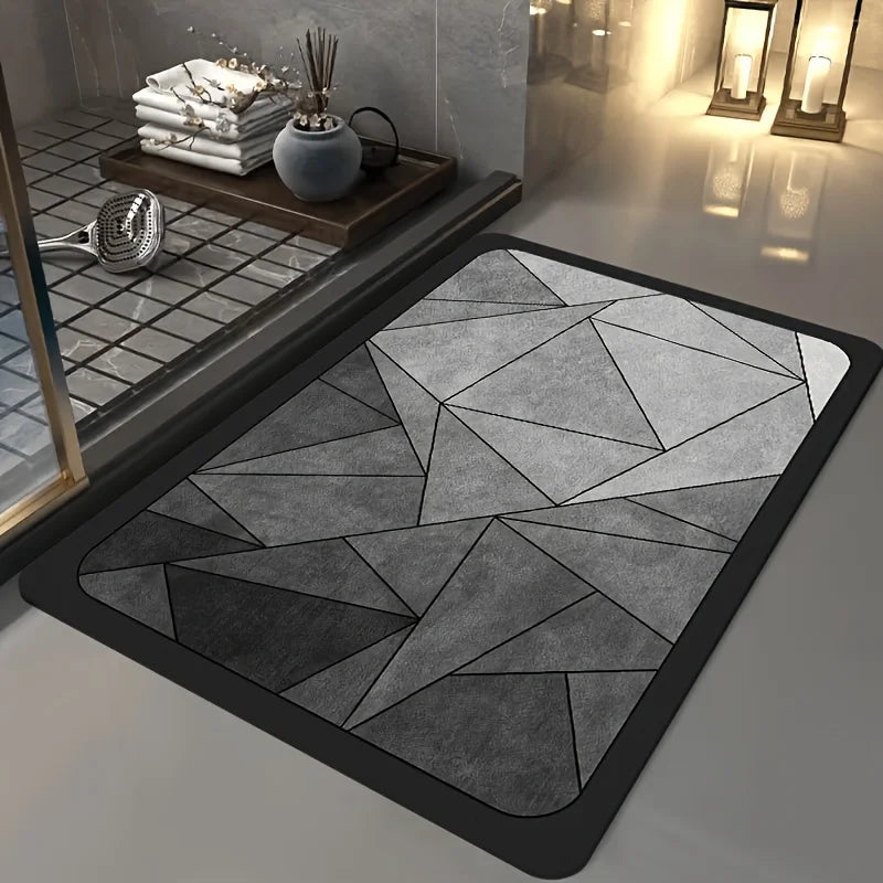 A rectangular gray bath mat with a geometric pattern is displayed on a modern bathroom counter.