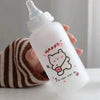 A clear water bottle with a pink label featuring a cute bear drawing and the text Happy Be happy every day