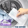 A hand is placing a white dryer sheet into the drum of a washing machine for fabric refreshment.