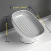 White ceramic countertop soap dish with a slatted drainage area and suction cup base.
