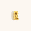 Nahaufnahme einer goldvergoldeten 3D-Blasen-Buchstaben-R-Kette.