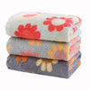 A stack of soft, grey and pink floral patterned kitchen cleaning cloths.