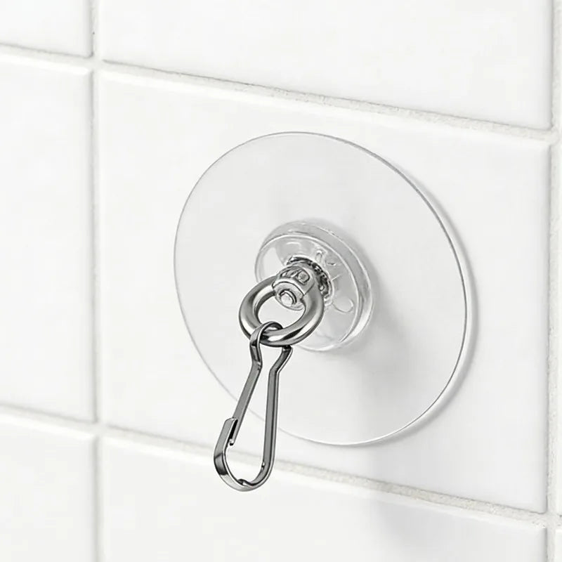 A round, silver self-adhesive stainless steel wall hook is mounted on a white tiled surface.