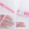Close-up view of pink mesh laundry bags with zippers and elastic closures for delicate clothing.