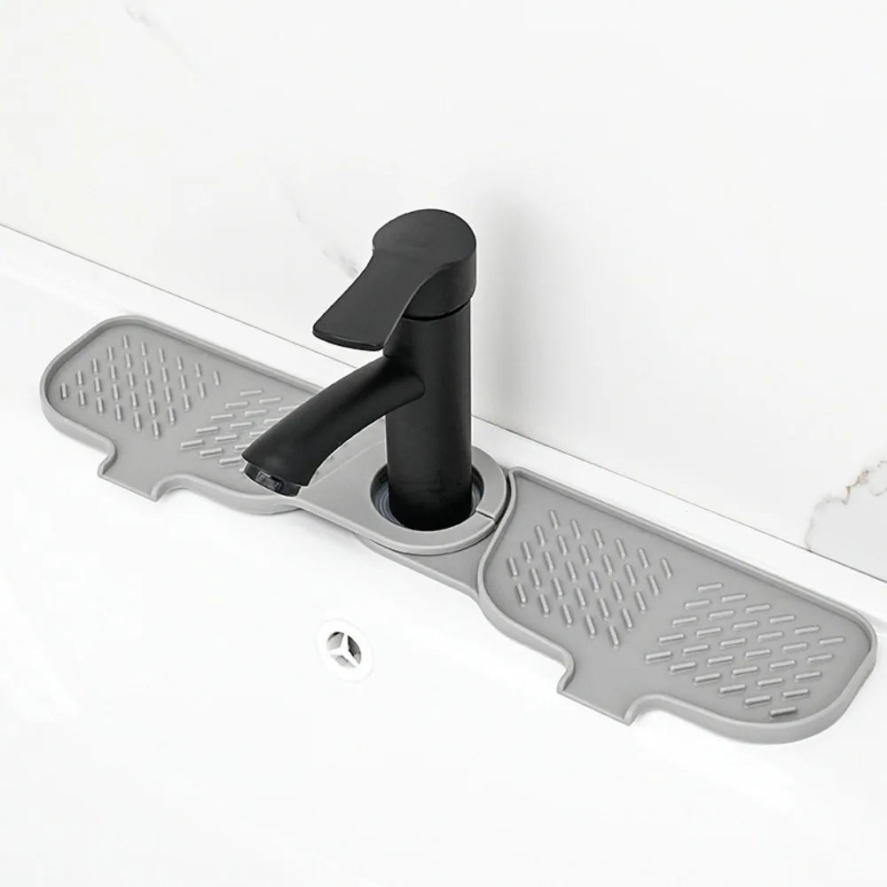 A black flexible silicone sink splash guard drip catcher mat mounted on a white countertop.