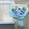 A handmade crochet flower bouquet featuring blue and yellow flowers with a handwritten message