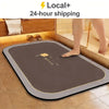 A brown diatomite bath mat is placed on a tiled floor next to a bathtub.