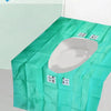 A green disposable waterproof toilet seat cover is shown in a packaged form.