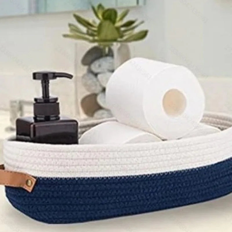 A navy blue woven cotton storage basket holding a roll of white paper and a black dispenser.