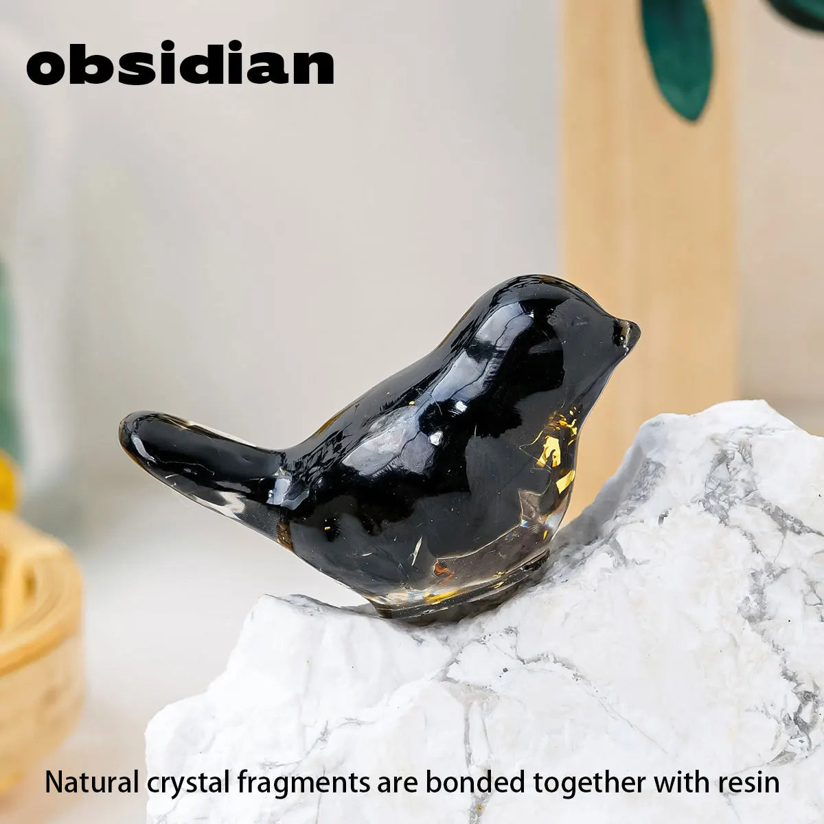 A glossy black obsidian bird statue resting on a white marble surface.