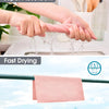 Hands are squeezing a pink reusable microfiber cleaning cloth, demonstrating its absorbency and fast drying properties.