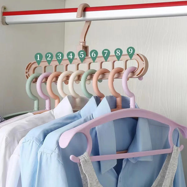 A wooden clothes hanger rack with nine numbered hooks and a pink hanger bar displaying light blue shirts.