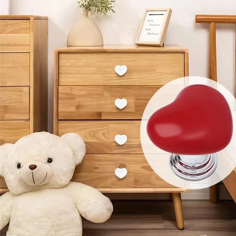 Un bouton de chasse d'eau en forme de cœur rouge à côté d'une commode en bois et d'un ours en peluche blanc.