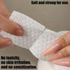 A hand is holding a white cotton pad, demonstrating its soft and strong texture for use.