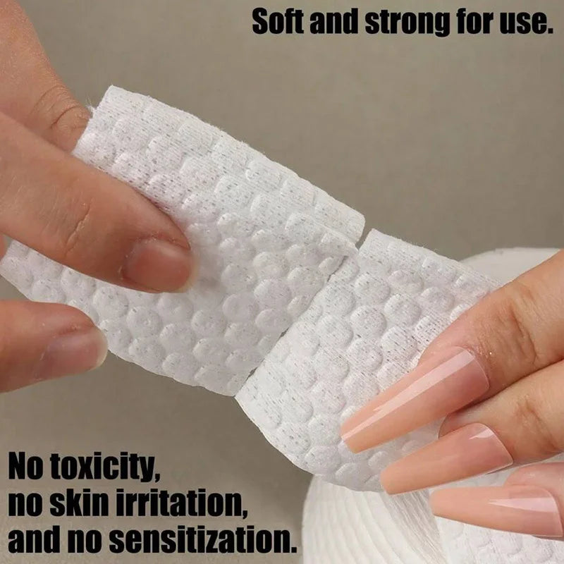 A hand is holding a white cotton pad, demonstrating its soft and strong texture for use.