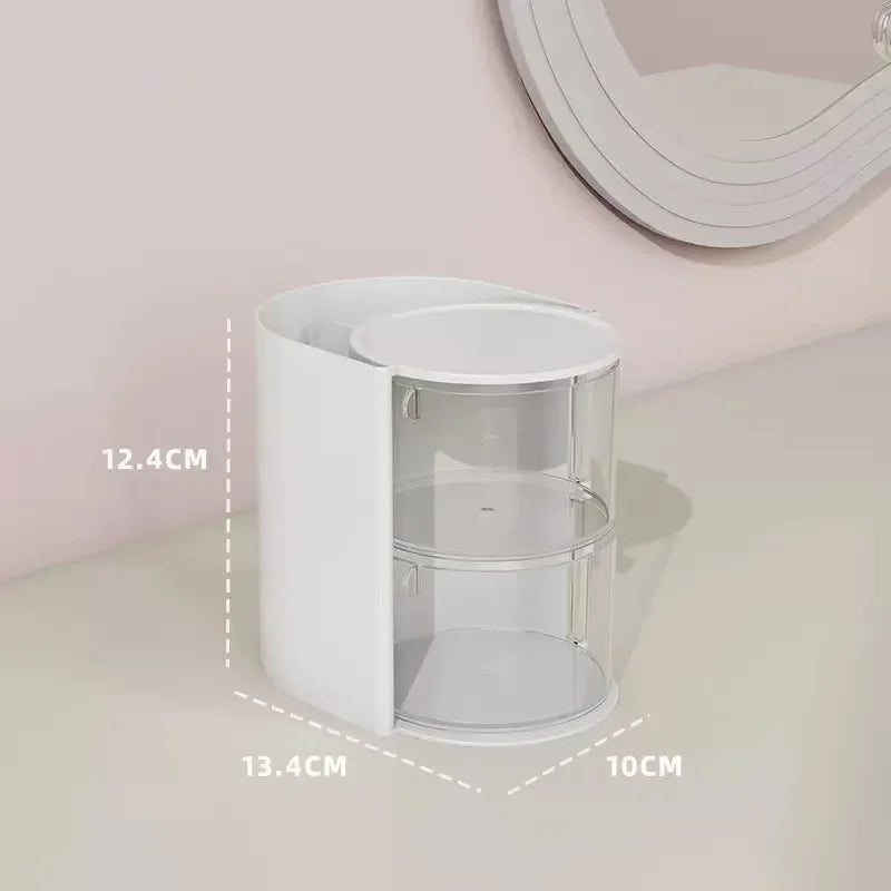 A white acrylic rotating hair accessories and makeup organizer with clear compartments.