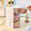 A white acrylic rotating organizer holds colorful hair accessories and makeup items.