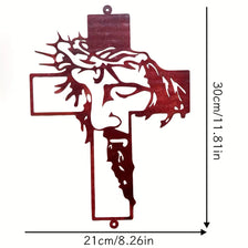 A dark reddish-brown metal cross wall art featuring a carved face design.