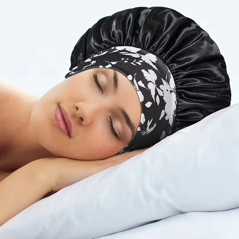 Una mujer duerme con un gorro de satén negro en la cabeza, apoyada en una almohada blanca.