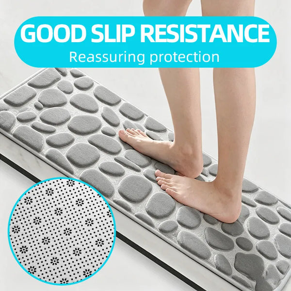 A person's feet resting on a gray, textured non-slip mat designed for good slip resistance.