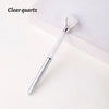 A clear quartz crystal pen with a silver barrel and a clear crystal tip resting on a white surface.