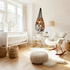 A macrame stuffed animal storage hammock hangs on a wall in a bright room with natural light and wooden furniture.