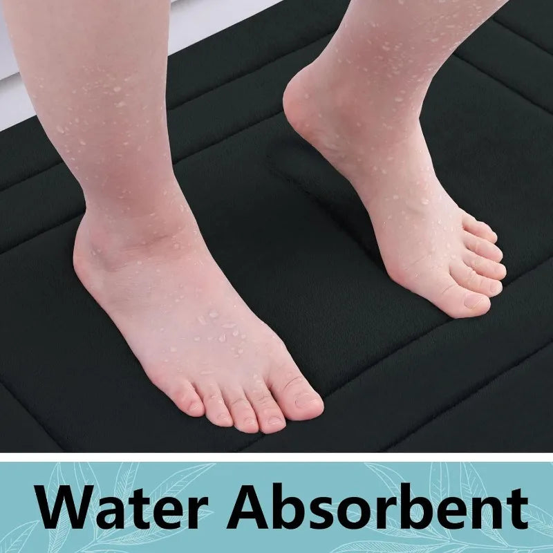 A close-up of a foot resting on a black absorbent bath mat, showing water absorption.