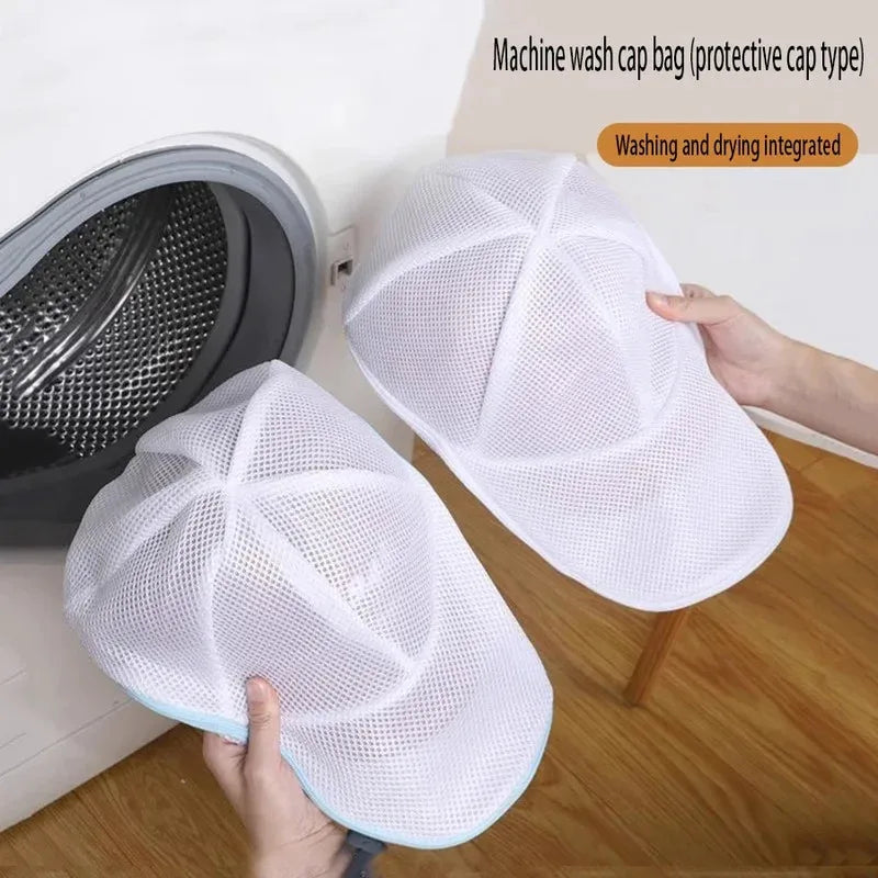 A white mesh wash bag designed to protect hats, shown next to a washing machine.
