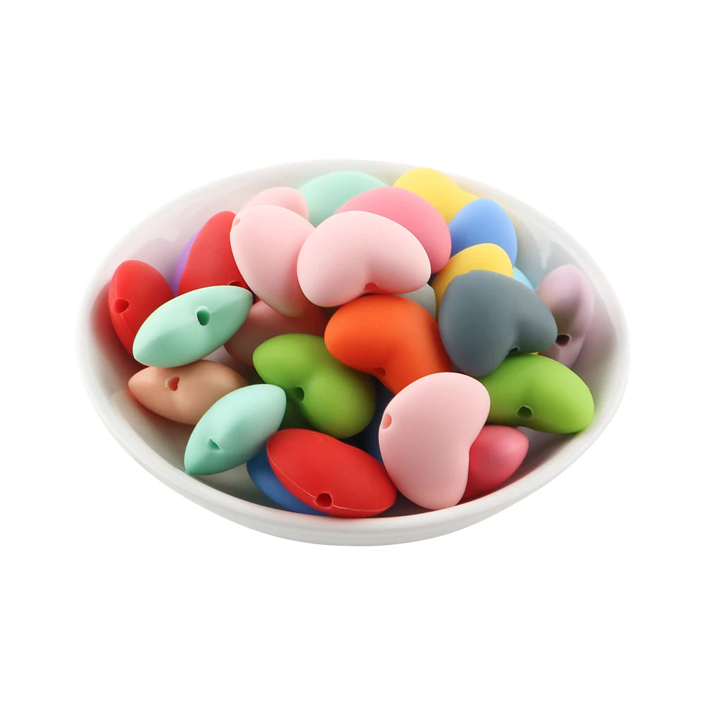 A pile of ten colorful hot heart silicone charm beads in various shades of pink, green, yellow, and orange.