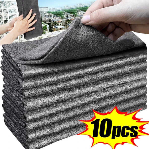 A stack of ten gray microfiber cleaning cloths being held by a hand.