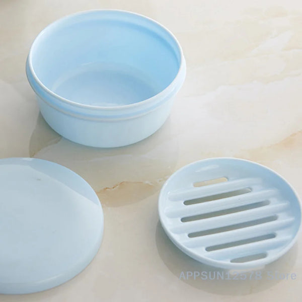 Light blue circular waterproof soap box with a drainage cover resting on a marble surface.