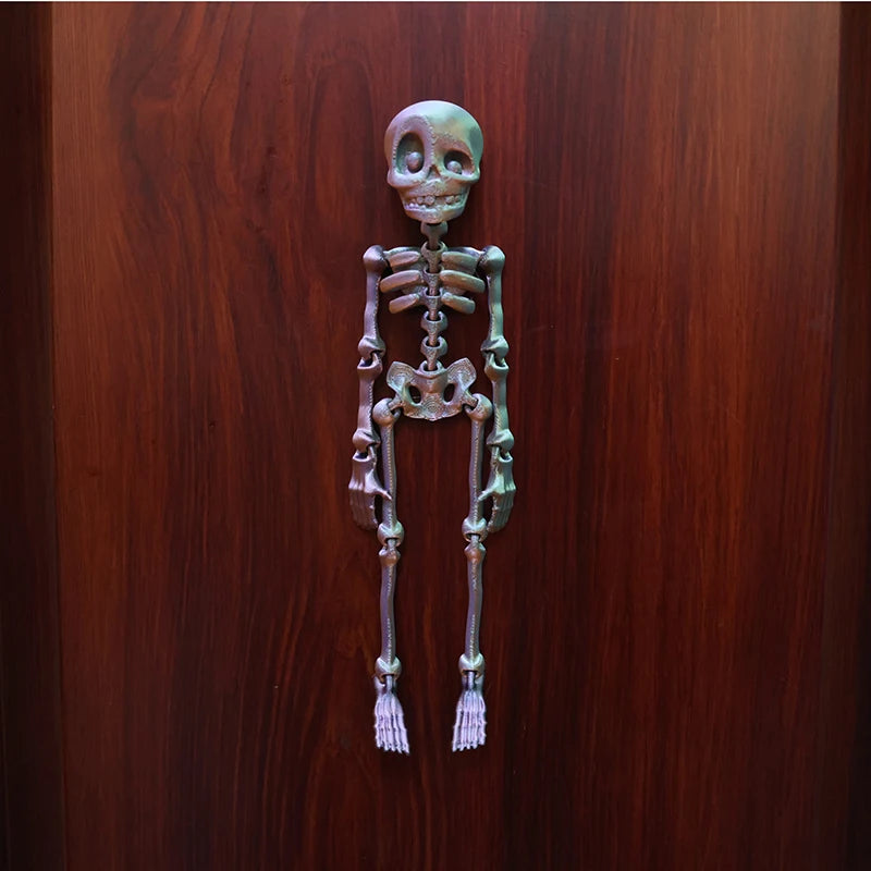 A set of luminous magnetic poseable skull fridge magnets displayed against a dark wooden background.