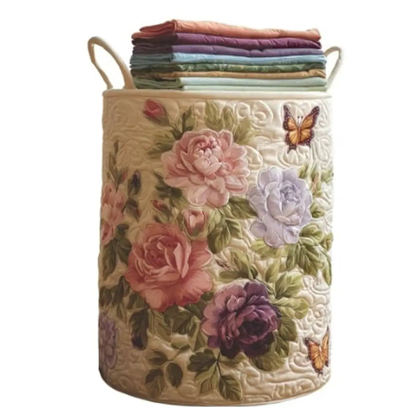 A beige quilted laundry basket with handles filled with folded purple and green fabric.