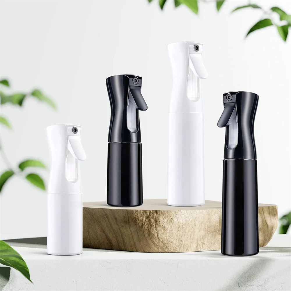 A set of three black and white multi-functional handheld spray bottles displayed on a wooden surface.