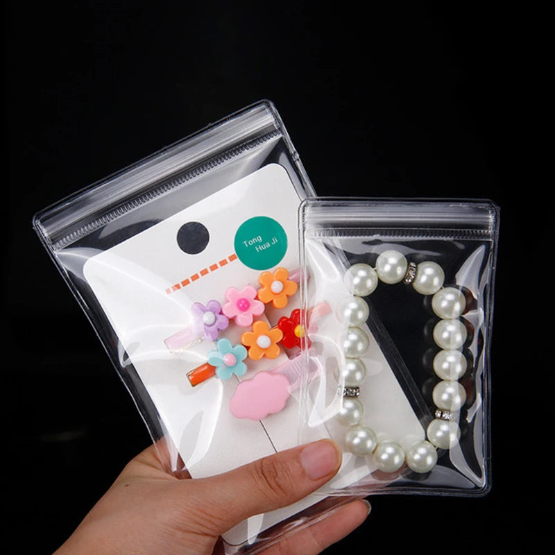 Two clear PVC zip lock jewelry pouches containing beaded necklaces and earrings.