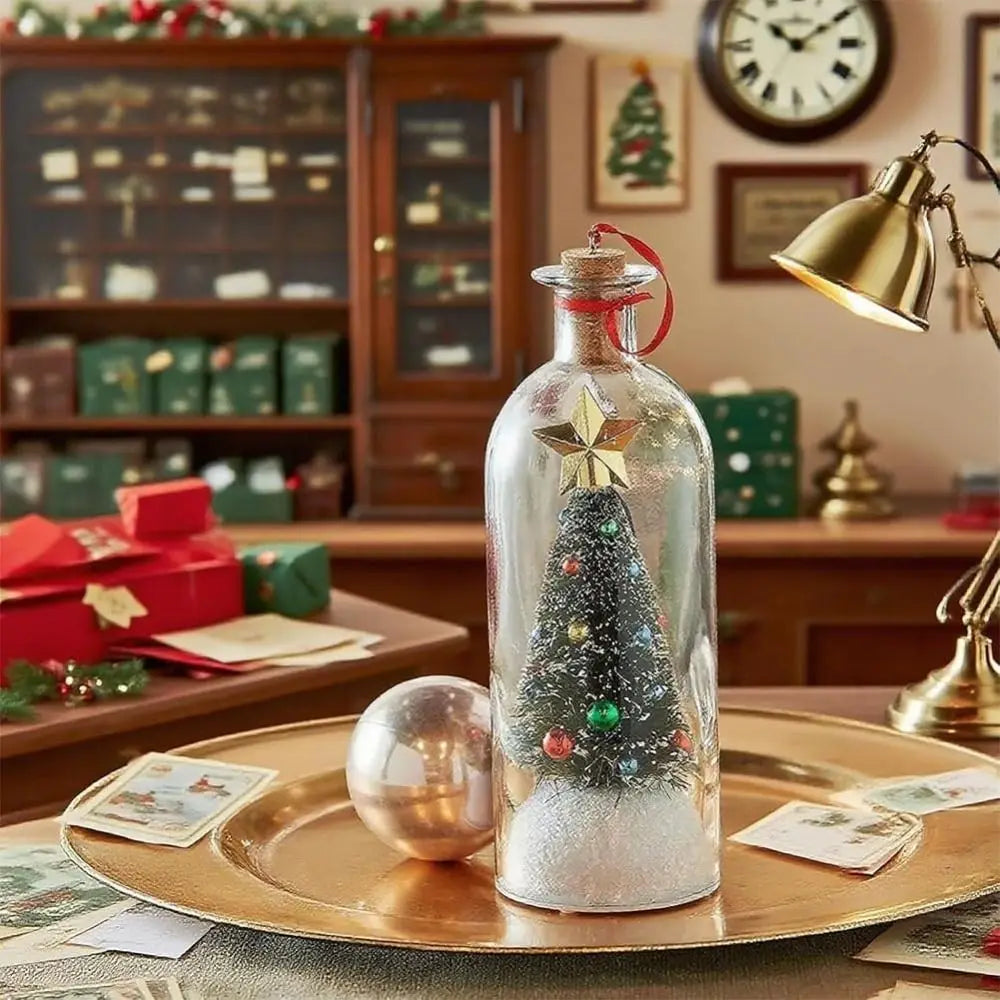 A glass message bottle decorated with a Christmas tree and glitter sits on a gold plate in a festive setting.
