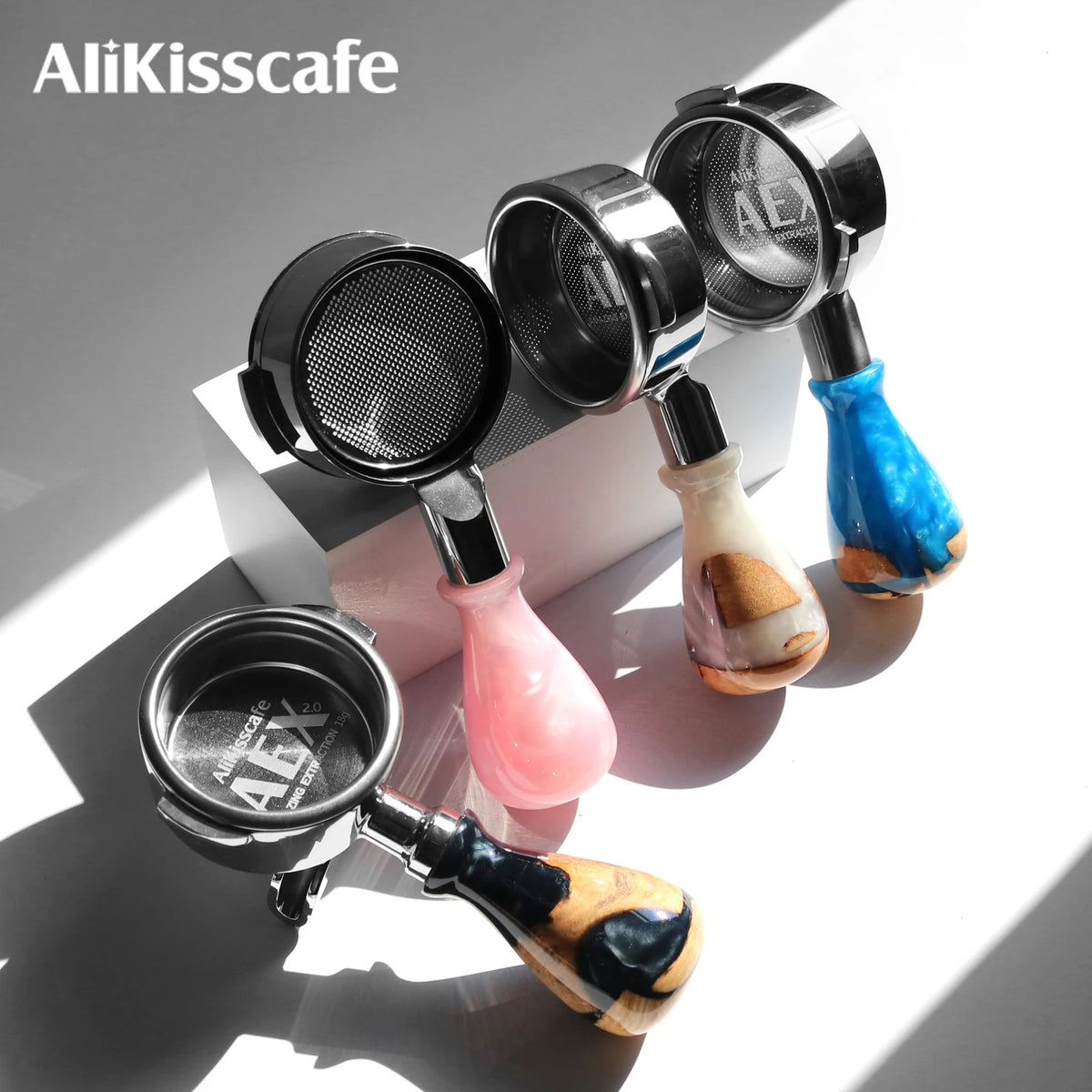 Colección de portafiltros de café de plata y cobre para máquinas de espresso, mostrados sobre una superficie blanca.