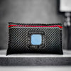A black reusable silica gel dehumidifier bag with a red trim and a light blue oval label.