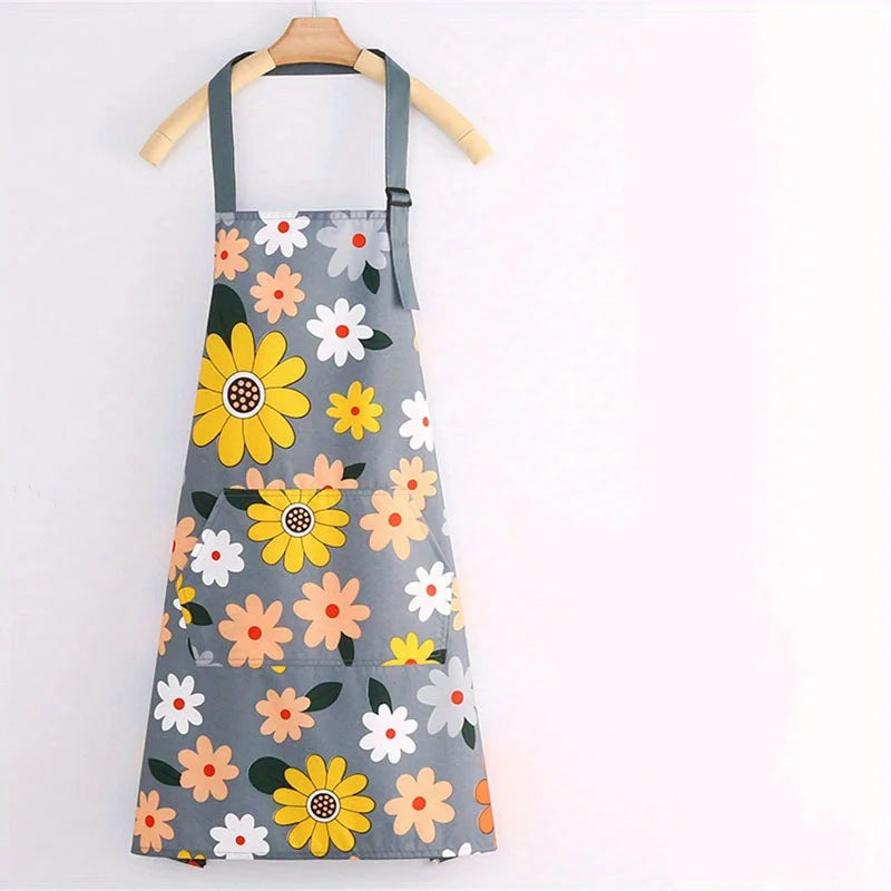 Gray apron with a floral print featuring yellow and white daisies, hanging on a wooden hanger.