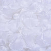 Pétalos de rosa de seda artificial blanca esparcidos sobre una superficie.