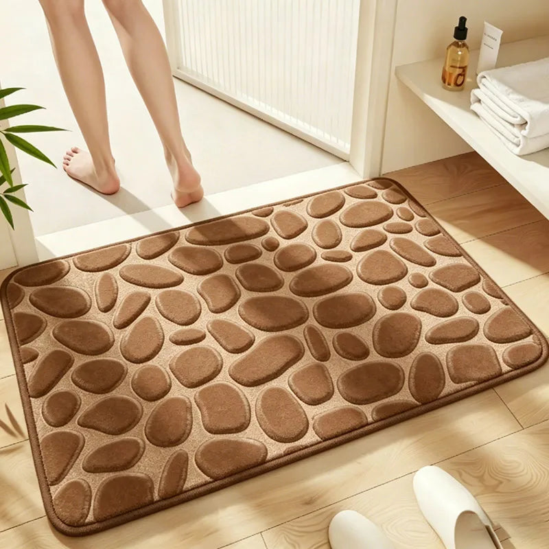 A brown, pebble-textured bath mat is placed on a light wooden floor next to a white radiator.