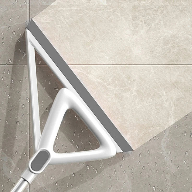 A silver silicone window and surface cleaner is shown angled against a light beige tiled surface.