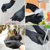 Hands in black nitrile gloves are washing a glass under running water.