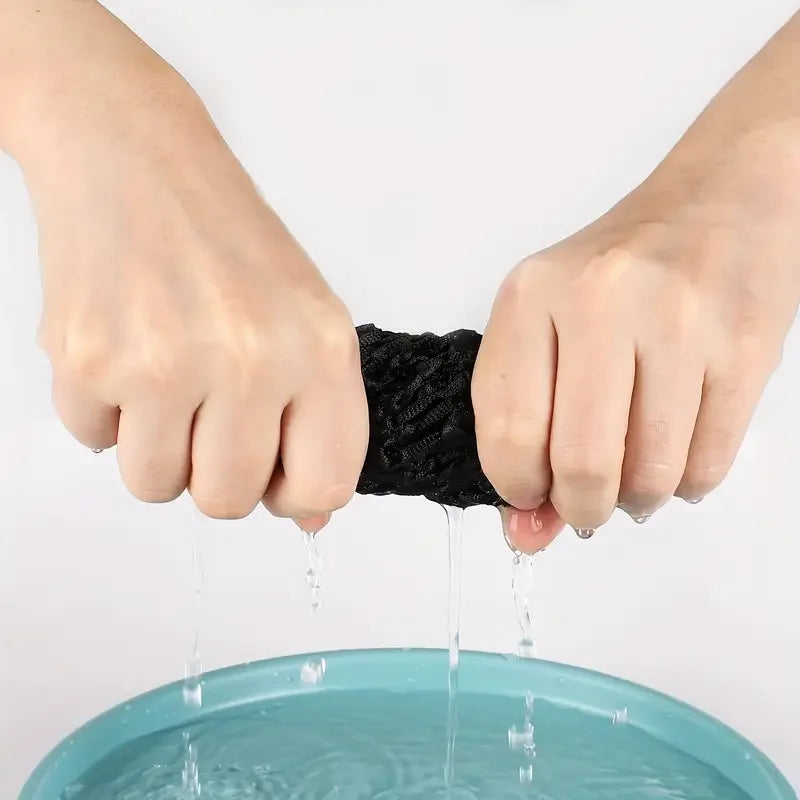Hands dripping water onto a teal surface, demonstrating an adjustable mesh wig cap.