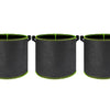 Three black breathable fabric plant grow bags with green trim and handles