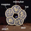 A set of traditional copper Feng Shui coins featuring animals like magpies, bat, peach, deer, and monkey.