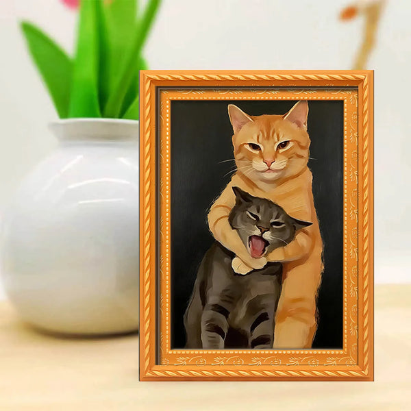 A framed painting depicting an orange cat holding a black kitten, set against a dark background.