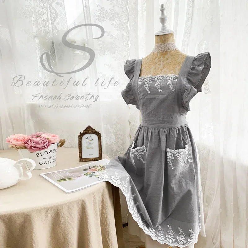 Graues Leinen-Baumwoll-Schürzenkleid mit Spitzenverzierungen auf einem Mannequin.