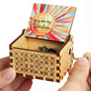 An antique wooden hand crank music box with a lid featuring a sunburst design and a decorative wooden box.